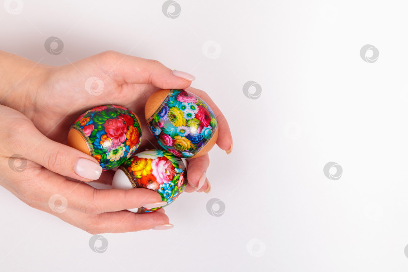 Скачать Пасха. Хохломские яйца в руках девушки, на светлом фоне. фотосток Ozero