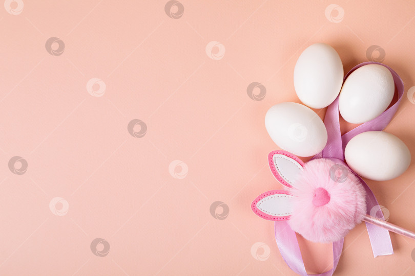 Скачать Пасха. Белые яйца с искусственным кроликом на однородном фоне. фотосток Ozero