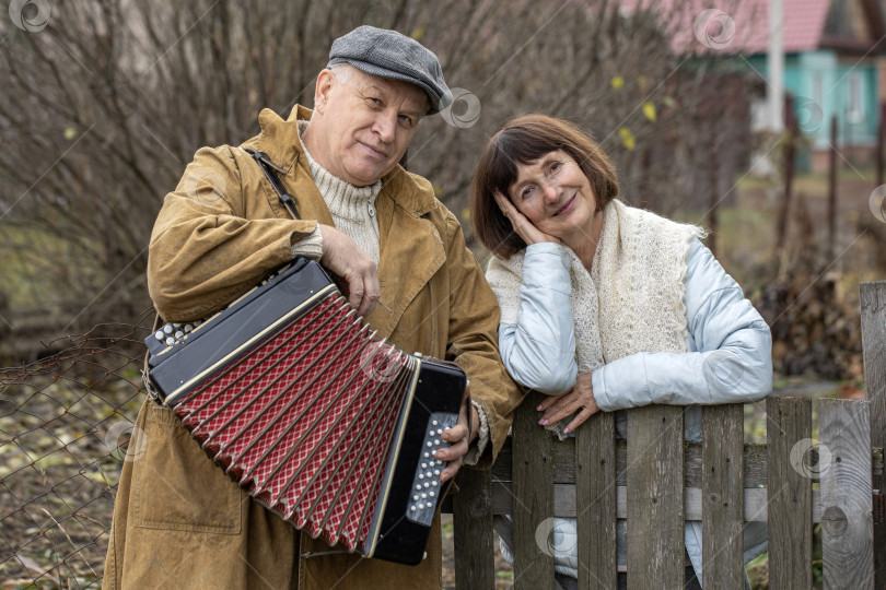 Скачать Соседи по даче. Пожилая пара у деревянного забора. фотосток Ozero