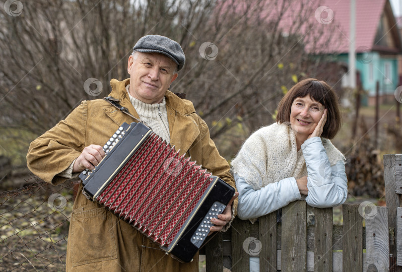 Скачать Соседи по даче. Пожилая пара у деревянного забора. фотосток Ozero
