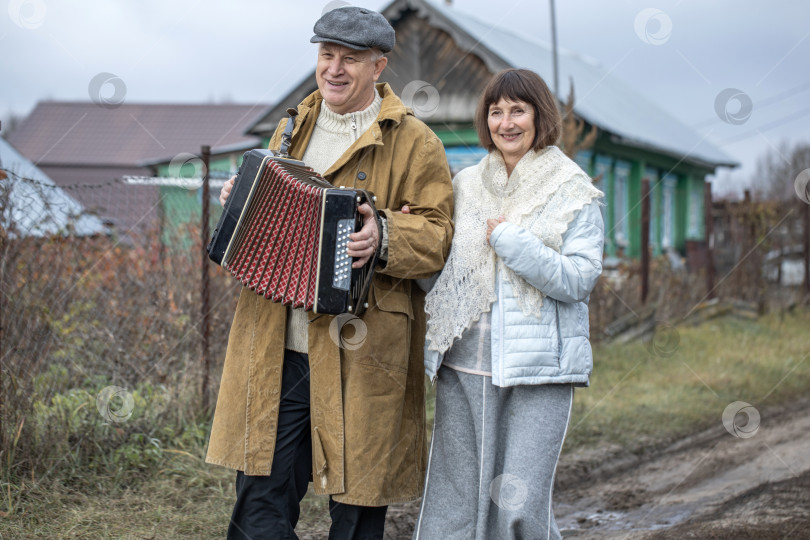 Скачать Супружеская пара пенсионеров прогуливается по деревне. фотосток Ozero
