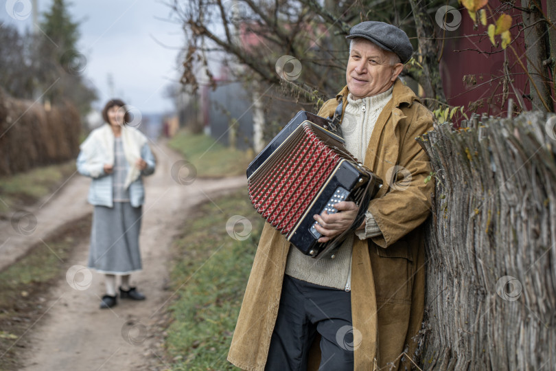 Скачать Пожилой деревенский житель с аккордеоном фотосток Ozero