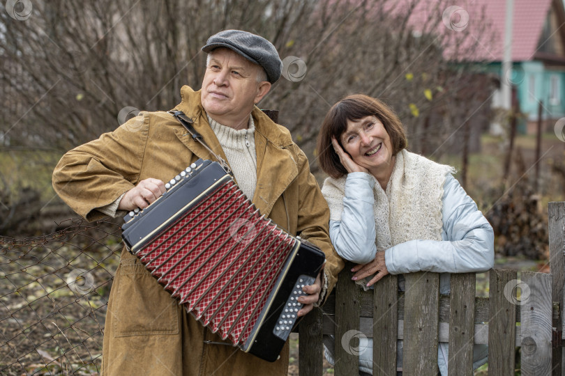 Скачать Соседи по даче. Пожилая пара у деревянного забора. фотосток Ozero