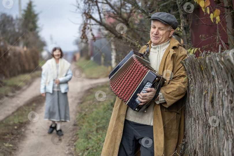 Скачать Пожилой деревенский житель с аккордеоном фотосток Ozero