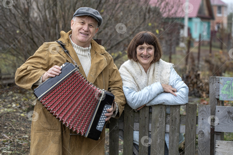 Скачать Соседи по даче. Пожилая пара у деревянного забора. фотосток Ozero