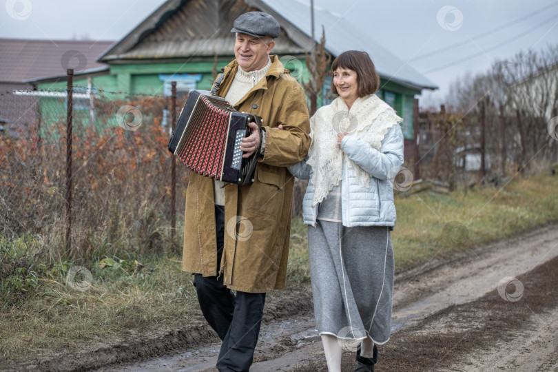 Скачать Супружеская пара пенсионеров прогуливается по деревне. фотосток Ozero