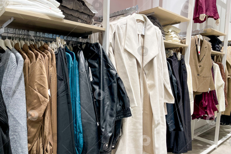 Скачать Тканевые платья, рубашки, брюки на вешалках в шкафах-купе в магазине shopping center mall фотосток Ozero