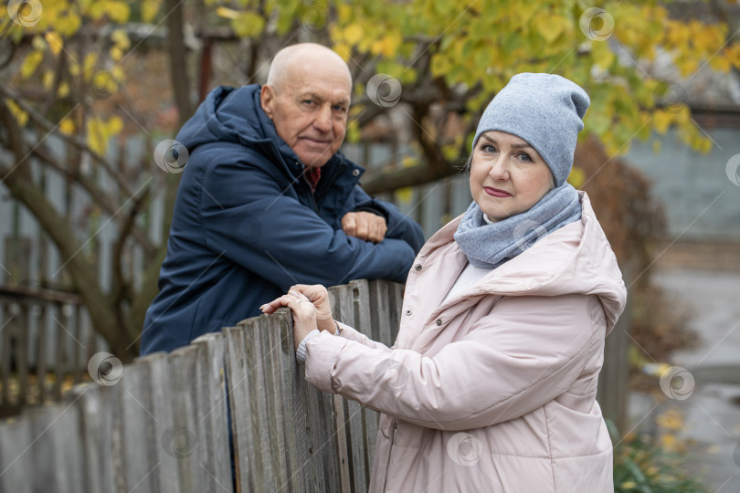 Скачать Соседи по даче. Пожилая пара у деревянного забора. фотосток Ozero