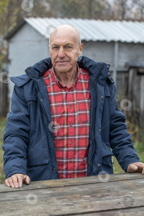 Скачать Одинокий сосед. Пожилой мужчина у деревянного стола фотосток Ozero