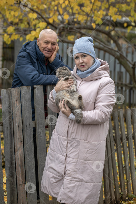 Скачать Соседи по даче. Пожилая пара у деревянного забора. фотосток Ozero