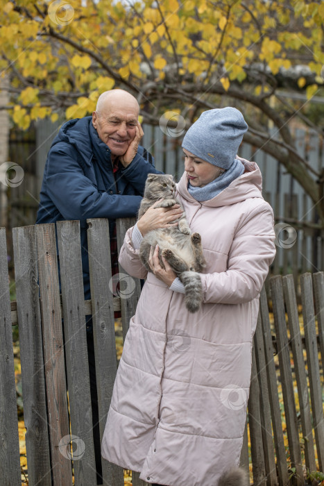 Скачать Соседи по даче. Пожилая пара у деревянного забора. фотосток Ozero
