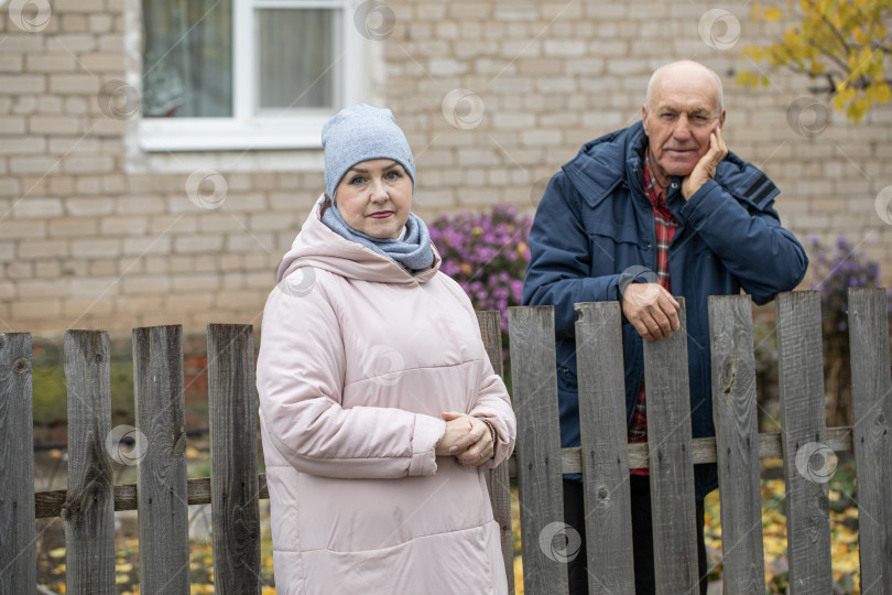 Скачать Соседи по даче. Пожилая пара у деревянного забора. фотосток Ozero