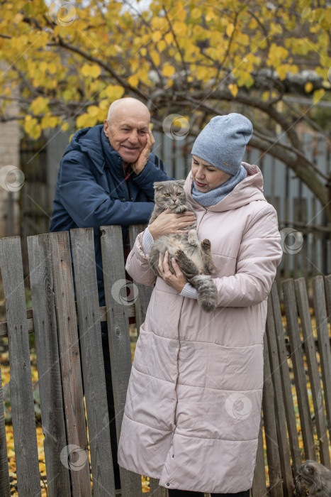Скачать Соседи по даче. Пожилая пара у деревянного забора. фотосток Ozero