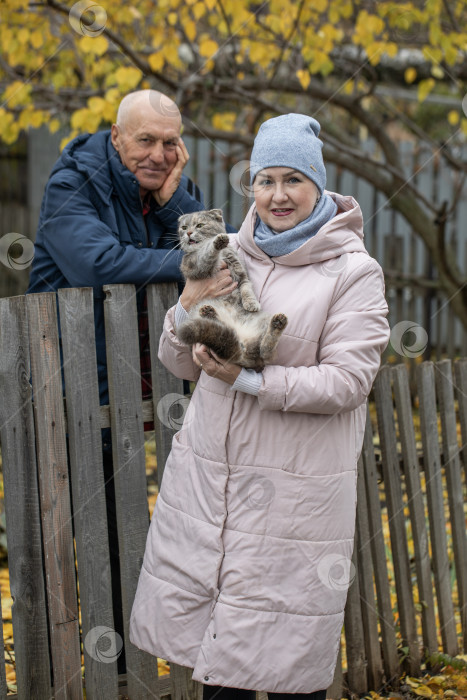 Скачать Соседи по даче. Пожилая пара у деревянного забора. фотосток Ozero