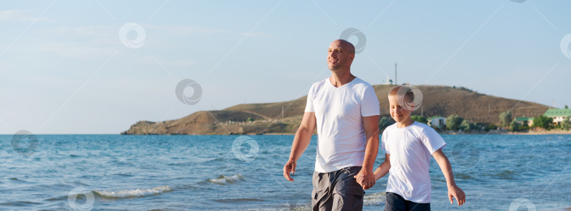Скачать Мужчина и мальчик прогуливаются по пляжу фотосток Ozero