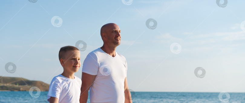 Скачать Мужчина и мальчик стоят на пляже фотосток Ozero