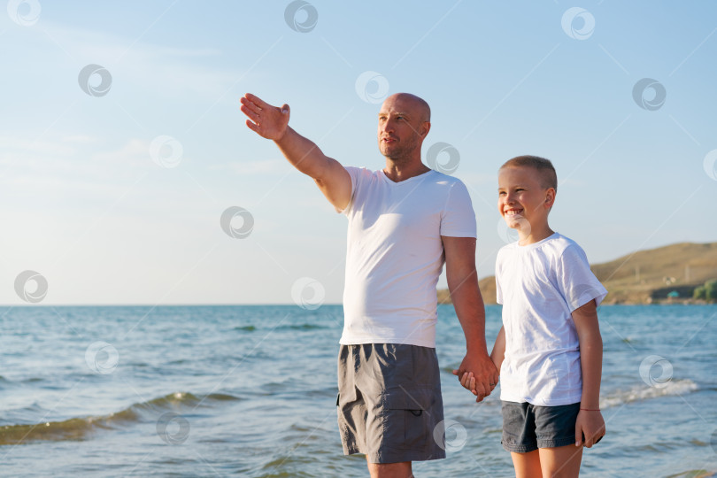 Скачать Мужчина и мальчик стоят на пляже фотосток Ozero