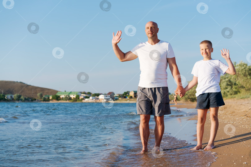 Скачать Мужчина и мальчик стоят на пляже фотосток Ozero