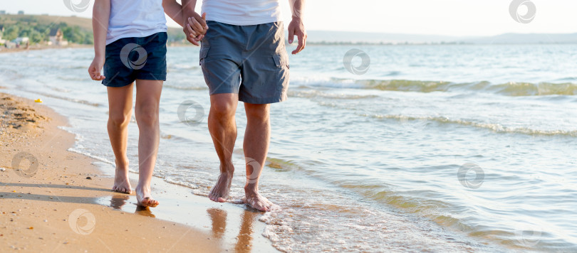 Скачать Два человека прогуливаются по пляжу фотосток Ozero