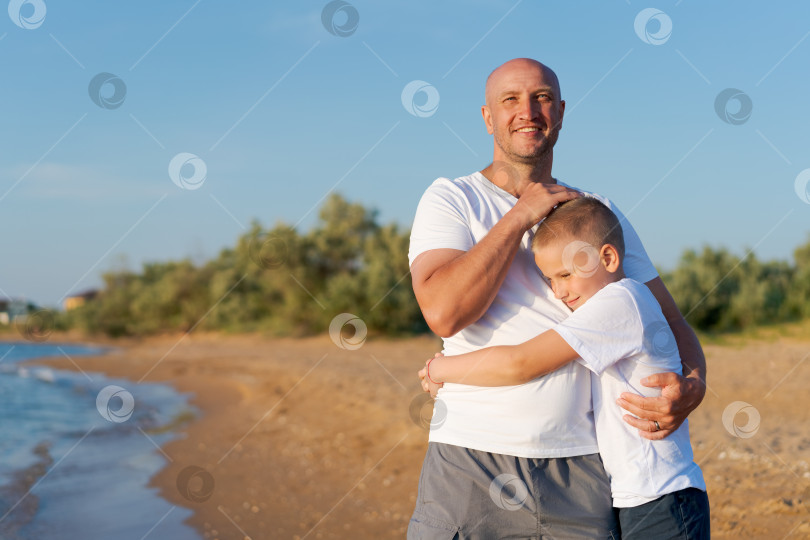 Скачать Мужчина и мальчик стоят на пляже фотосток Ozero