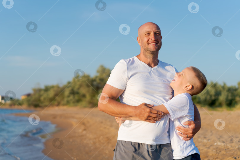 Скачать Мужчина и мальчик стоят на пляже фотосток Ozero