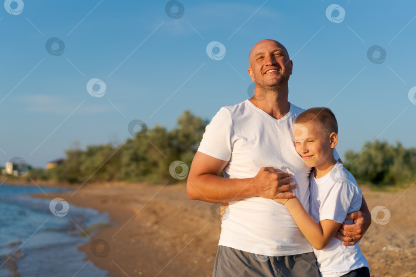 Скачать Мужчина и мальчик стоят на пляже фотосток Ozero