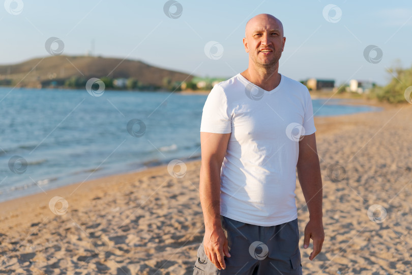 Скачать Мужчина, стоящий на пляже в белой рубашке и серых шортах фотосток Ozero