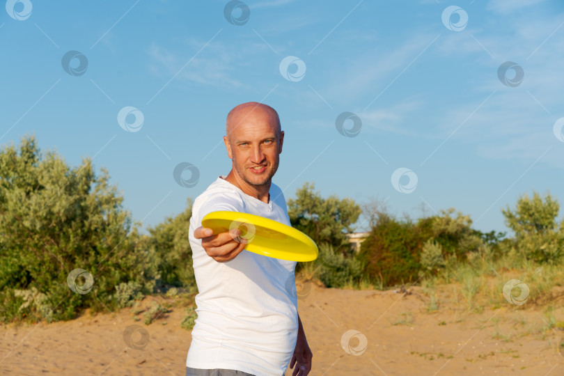 Скачать Мужчина держит в руках желтую летающую тарелку фотосток Ozero