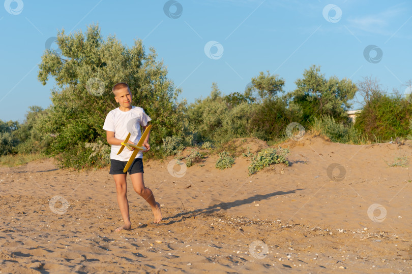 Скачать Мальчик играет с воздушным змеем на песчаном пляже фотосток Ozero