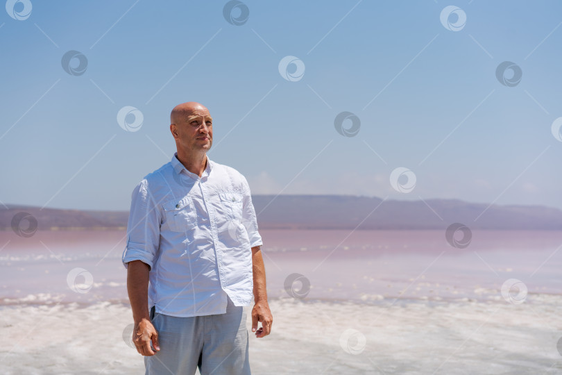 Скачать Мужчина в белой рубашке стоит на пляже фотосток Ozero