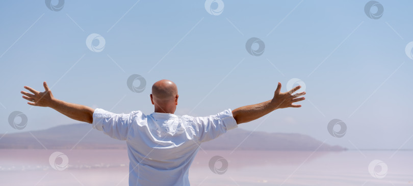 Скачать Мужчина стоит на пляже и протягивает к нему руки фотосток Ozero