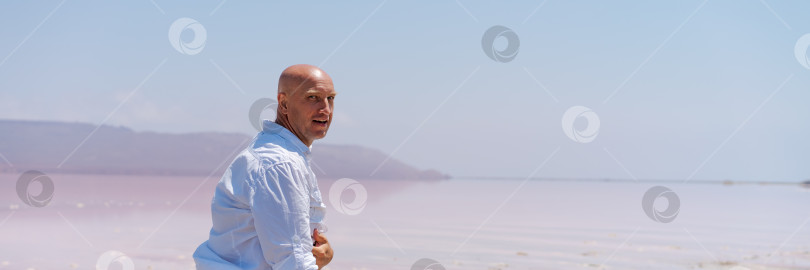 Скачать Мужчина стоит на пляже, скрестив руки на груди фотосток Ozero