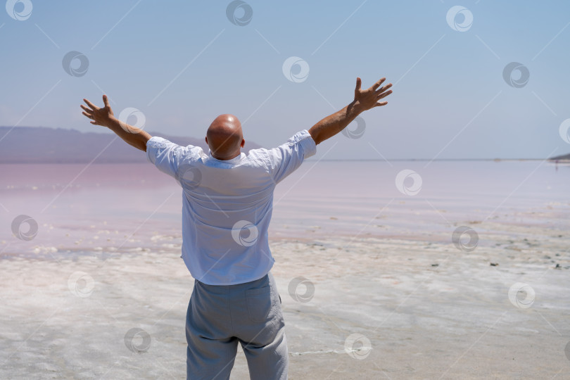 Скачать Мужчина, стоящий на пляже с поднятыми руками фотосток Ozero