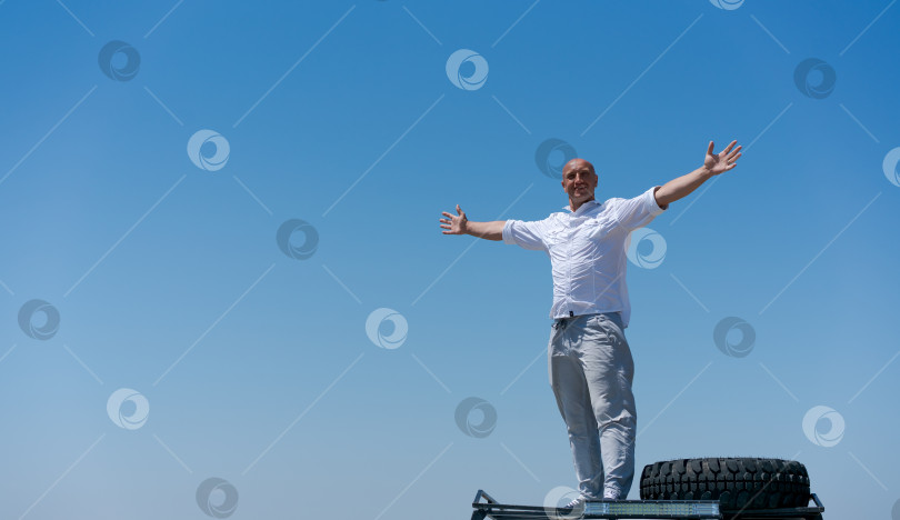 Скачать Мужчина стоит на шине и улыбается фотосток Ozero