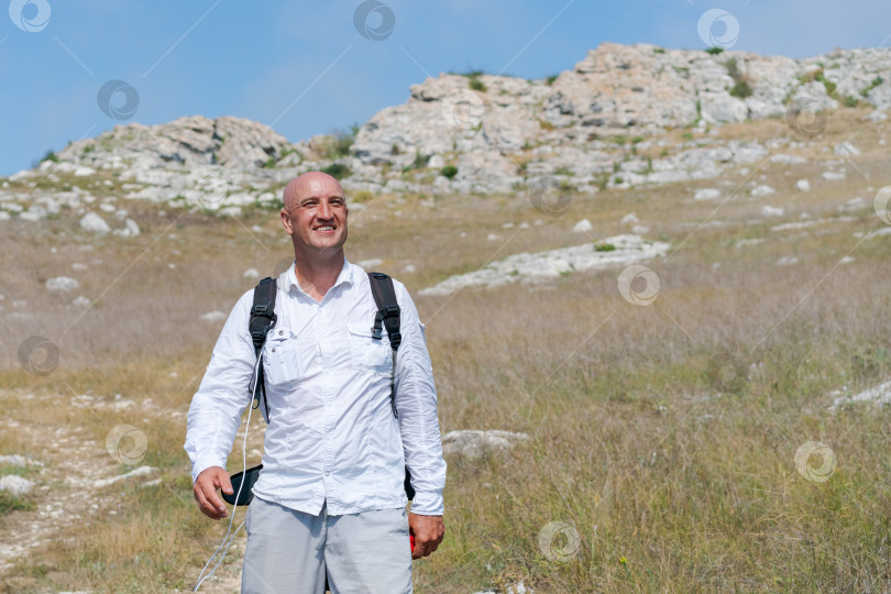 Скачать Мужчина в белой рубашке и серых шортах стоит в поле фотосток Ozero