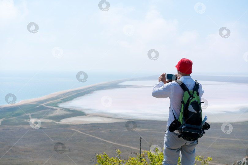 Скачать Мужчина в красной шляпе фотографирует океан фотосток Ozero