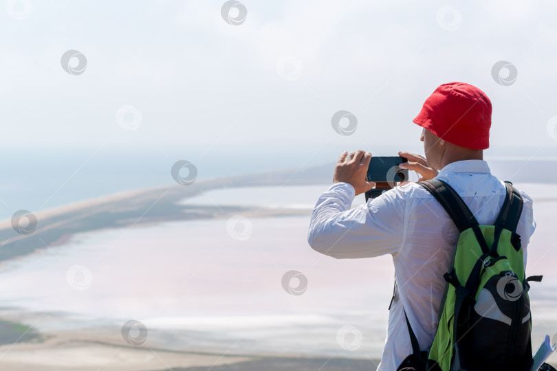 Скачать Мужчина в красной шляпе фотографирует океан фотосток Ozero