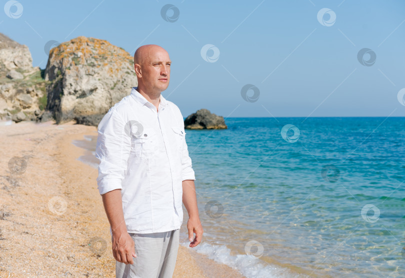 Скачать Мужчина стоит на пляже спиной к камере фотосток Ozero