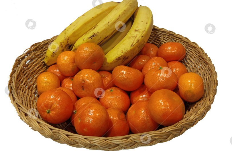 Скачать Яркие мандарины и спелые бананы лежат в традиционной плетеной корзине на чистом прозрачном фоне. фотосток Ozero