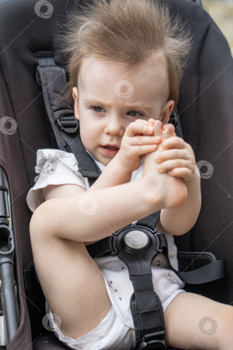 Скачать Портрет красивой маленькой девочки, сидящей в коляске фотосток Ozero