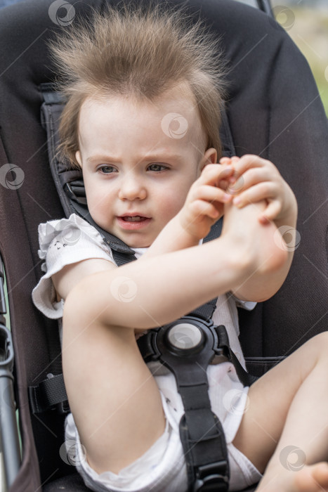 Скачать Портрет красивой маленькой девочки, сидящей в коляске фотосток Ozero