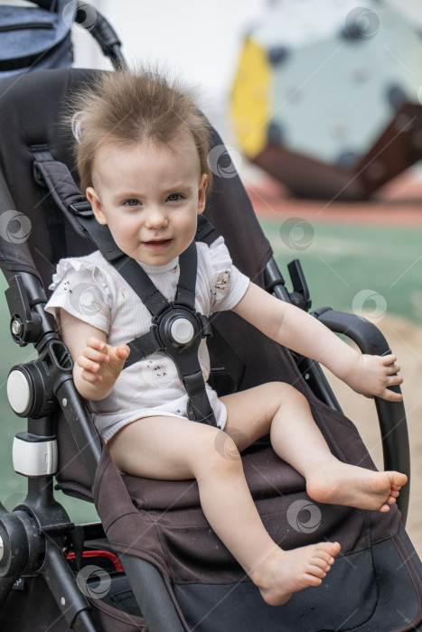 Скачать Портрет красивой маленькой девочки, сидящей в коляске фотосток Ozero