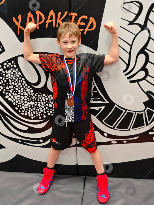 Скачать Ребенок с медалью после победы на соревнованиях.. Ребенок с медалью после победы в соревнованиях. фотосток Ozero