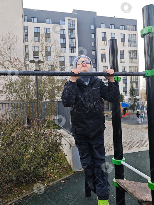 Скачать Ребенок в очках подтягивается на турнике фотосток Ozero