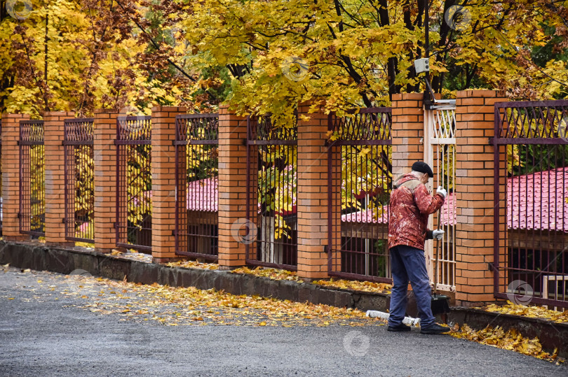 Скачать Дворник убирает территорию от листьев фотосток Ozero