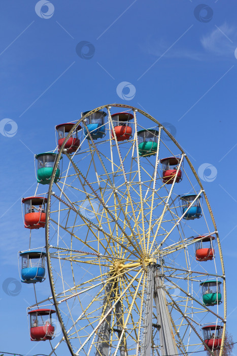 Скачать Аттракцион красочного колеса обозрения на фоне голубого неба фотосток Ozero