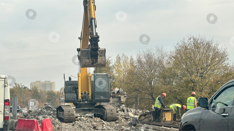 Скачать Строительные работы с экскаватором и рабочими на улице фотосток Ozero