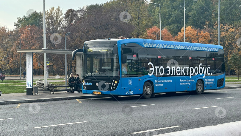 Скачать Электробус на автобусной остановке в осеннем городе фотосток Ozero