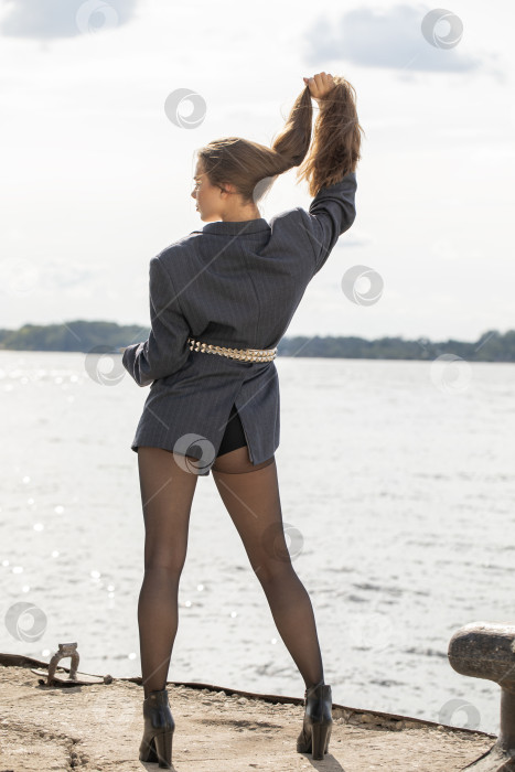 Скачать Портрет молодой брюнетки в полный рост в строгом пиджаке и черных колготках фотосток Ozero