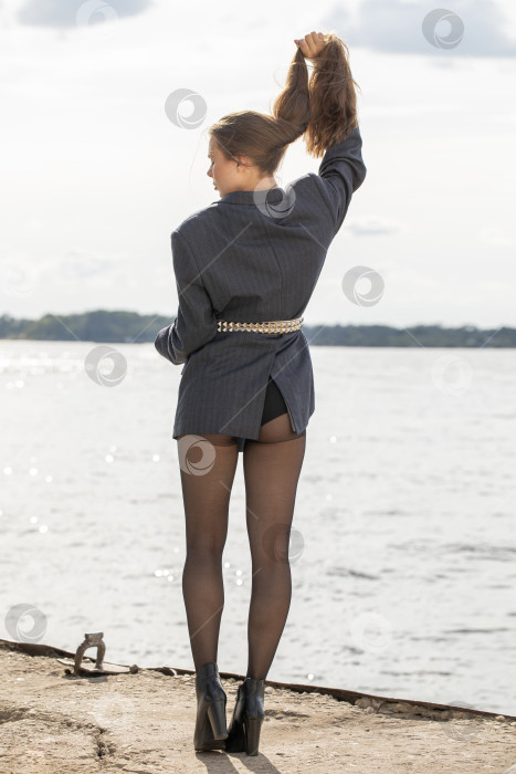 Скачать Портрет молодой брюнетки в полный рост в строгом пиджаке и черных колготках фотосток Ozero